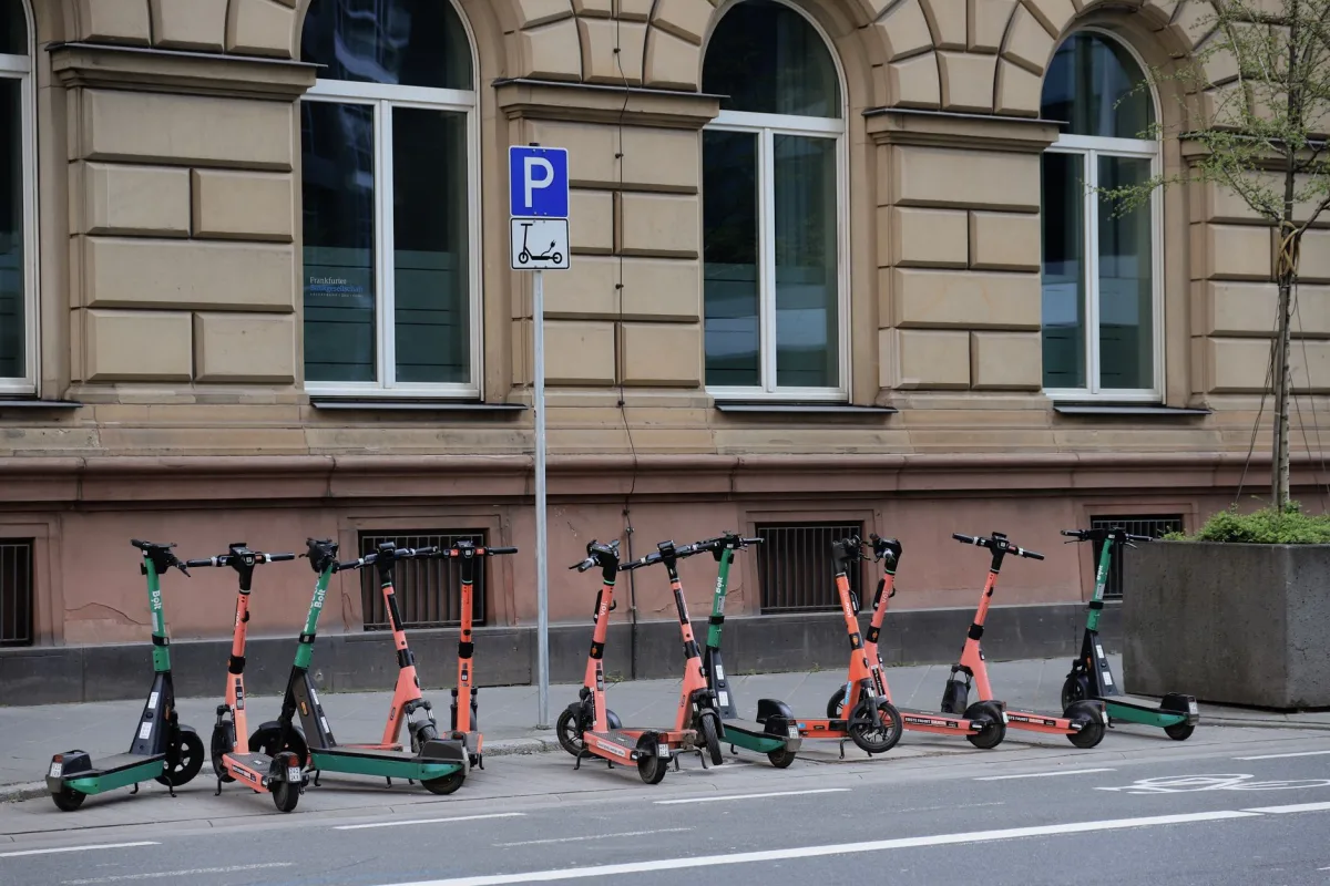 Row of electric scooters parked on a street in downtown Frankfurt, Germany.
